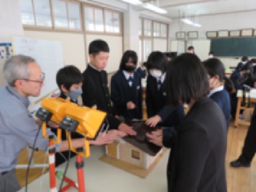 住宅模型の屋根の温度を確認する様子